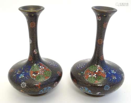 A pair of early 20thC cloisonne bottle vases with elongated necks and flared rims, with floral