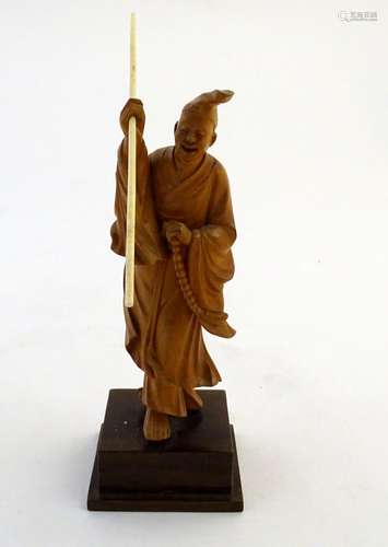 A 20thC figure modeled as an Oriental gentleman wearing robes and a hat. Approx. 7 3/4