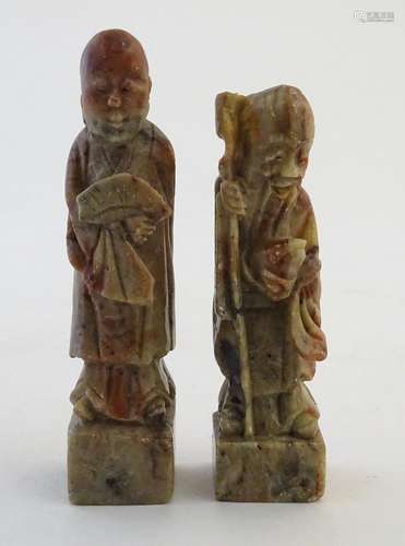 Two Oriental soapstone figures depicting an elder / scholar, and a man in robes with a fan.