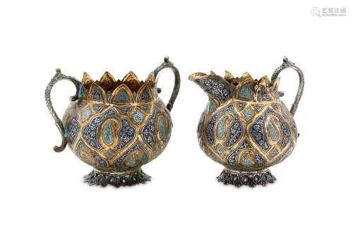 An early 20th century Anglo – Indian Raj unmarked silver parcel gilt and enamel milk jug and twin