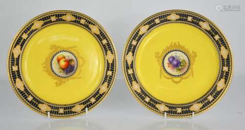 A pair of Royal Worcester porcelain plates painted with fruit and flowers, one signed Hale, the