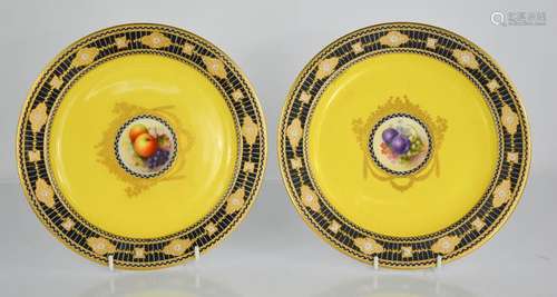 A pair of Royal Worcester porcelain plates painted with fruit and flowers, one signed Hale, the