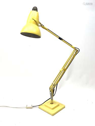 A yellow Herbert Terry & Sons Ltd Anglepoise lamp, on a square stepped base.