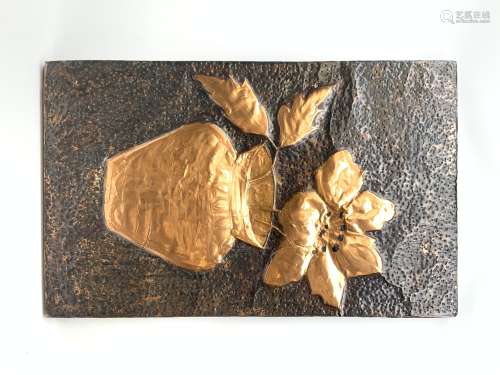 A hammered copper wall plaque, of rectangular form depicting in relief a flower contained within a v