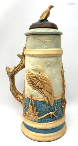 A large earthenware stein, decorated with a moulded continuous band of game birds, with confirming