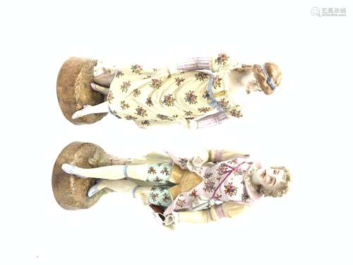 A pair of Continental porcelain figurines, the first modelled as a female figurine in floral dress,