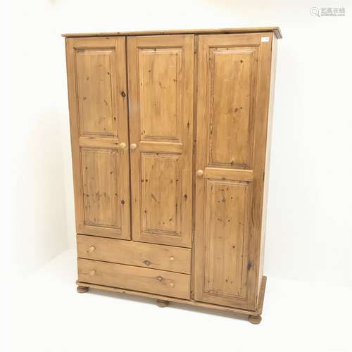 Pine triple combination wardrobe, three doors above two drawers on bun feet, W1325cm, H181cm, D51cm