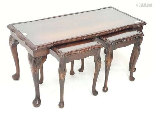 Late 20th century figured mahogany nest of tables, shaped moulded top with inset glass, on cabriole