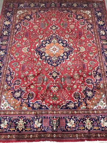 Kashan red ground rug carpet, the field decorated with scrolling stylised foliage with central medal