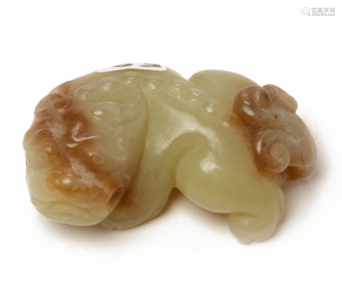 A SMALL CELADON AND RUSSET JADE CARVING OF A LION