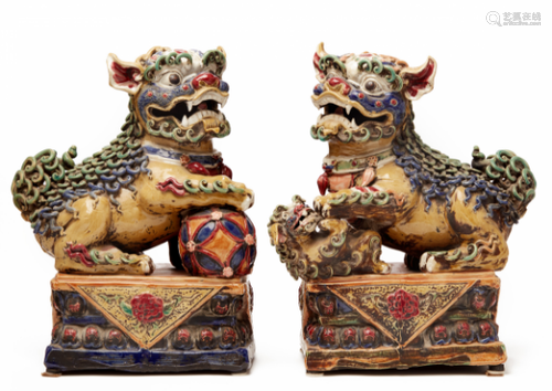 A PAIR OF VIVIDLY GLAZED POTTERY FOO DOGS (1)