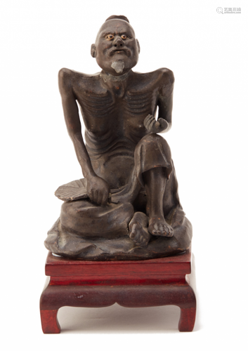 A GLAZED TERRACOTTA FIGURE OF A FASTING MONK