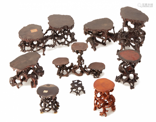 A GROUP OF EIGHT NATURALISTIC CARVED WOOD STANDS