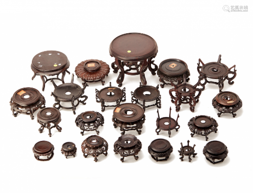 A GROUP OF TWENTY-THREE CARVED WOOD STANDS