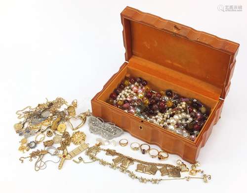 Vintage and later costume jewellery including brooches, necklaces and rings, housed in a tan