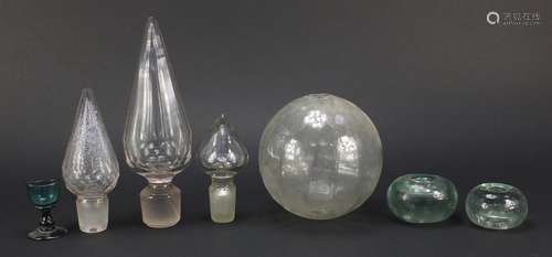 Antique glassware including three large decanter stoppers, two inkwells and an eyebath, the