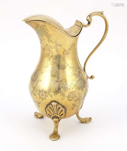 Silver gilt water jug with hinged lid, the body engraved with flowers and raised on three hoof feet,