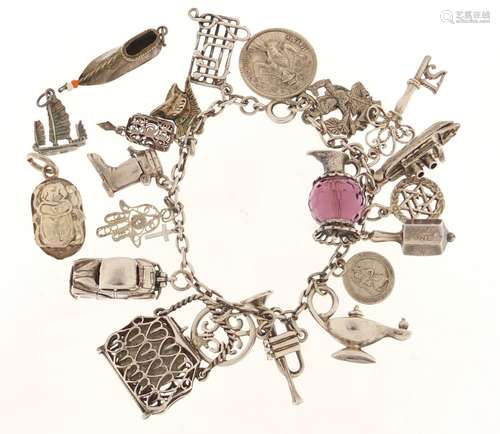 Silver charm bracelet with a large selection of mostly silver charms, including a scarab beetle,