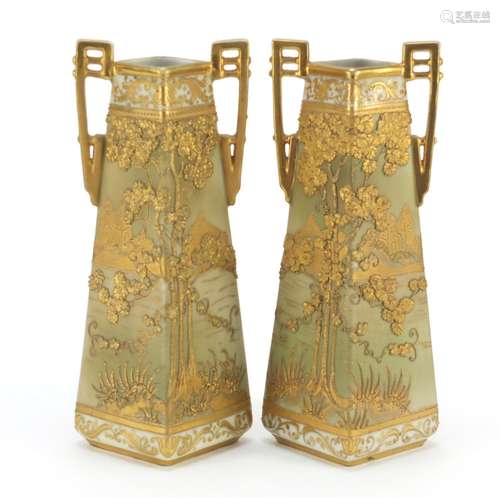 Pair of Noritake porcelain vases with twin handles gilded and decorated in relief with landscapes,