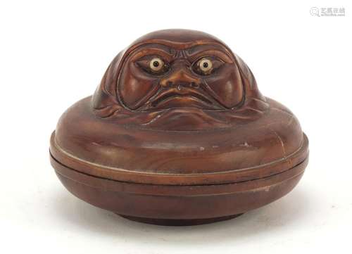 Japanese hardwood box and cover carved with a face, inset mother of pearl to the base, 6.6cm in