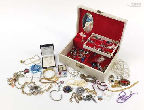 Vintage and later costume jewellery arranged in a musical jewellery box including brooches and