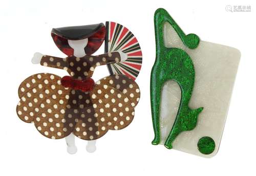 Two Lea Stein style brooches in the form of a stylised cat and girl holding a fan, the largest 7cm