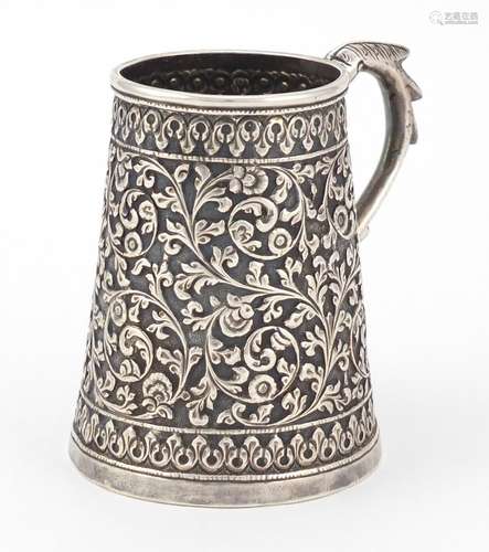 Indian unmarked silver tankard of conical form, profusely embossed with flowers and foliage, 9cm