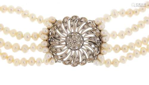 Four row pearl necklace with a large unmarked white metal diamond set clasp, 40cm in length, the