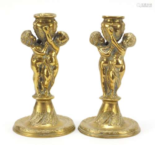 Pair of classical bronzed candlesticks with Putti columns, each 24cm high : For Further Condition