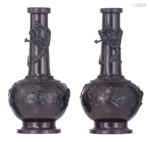 A pair of East Asian patinated bronze vases, relief decorated with a ****** and birds sitting on bra