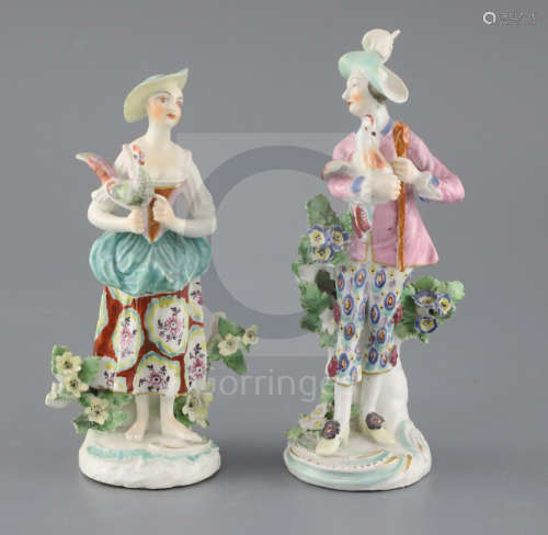 A pair of Derby groups, c.1765, modelled as a man and a woman holding a cockerel, on scrollwork