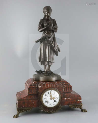 A 19th century French bronze and rouge marble mantel clock, surmounted with a bronze figure by