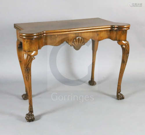 A George I walnut gaming table, with eared serpentine rectangular top, scallop shell carved