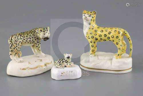 Three Staffordshire porcelain figures of leopards, c.1840-50, the largest on a rocky base, the other