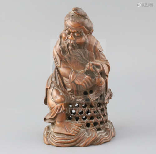 A Chinese bamboo figure of a fisherman, late 19th/early 20th century, the old man holding a fish