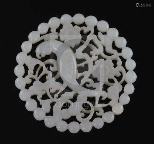A fine Chinese white jade disc, 18th/19th century, reticulated and carved with a bird amid prunus