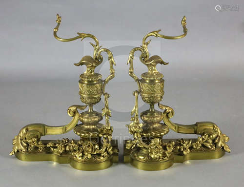 A pair of Louis XVI style ormolu chenets, modelled as urns mounted with scrolling floral foliage,