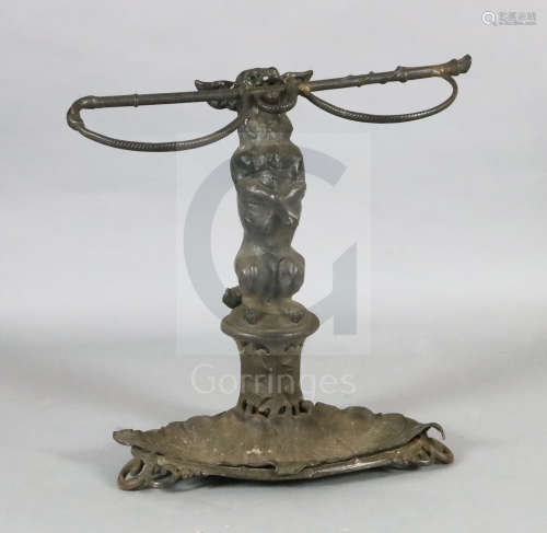 A Victorian cast iron stick stand, modelled as a terrier holding a riding crop, the oval base with