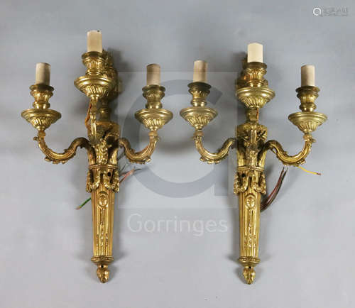 A pair of Adam revival ormolu three branch wall lights, with flaming urn and goat's head backplates,