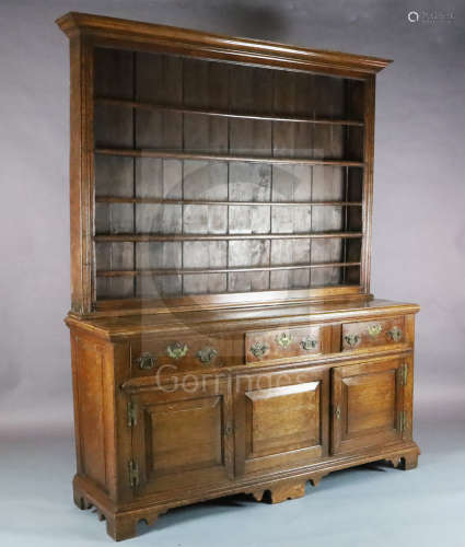 A mid 18th century oak dresser, with boarded three shelf rack, three long drawers and two panelled
