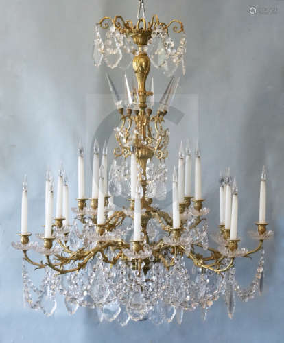A Louis XV style ormolu and cut glass twenty four light chandelier, with foliate scrolling