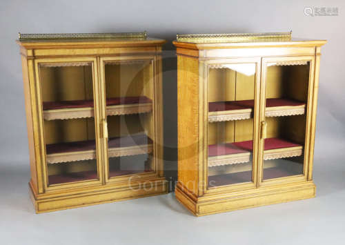 A pair of late Victorian Holland & Sons satinwood dwarf bookcases, with brass anthemion pattern back