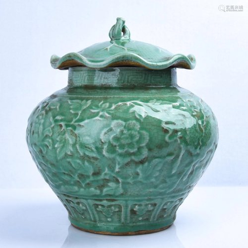 A CARVED LONGQUAN-CELADON JAR AND COVER.…