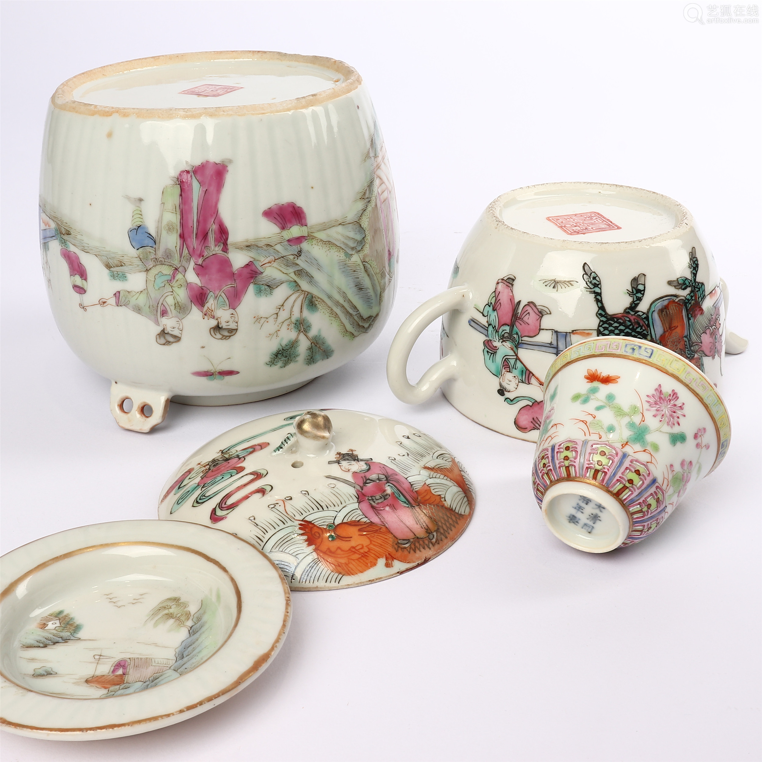 a set of teapots and cups decorated with famille rose figures