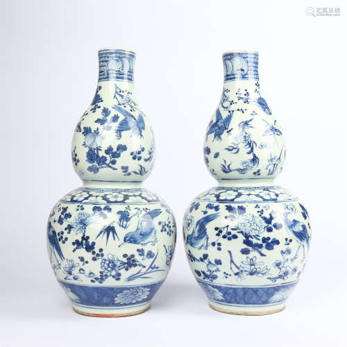 A pair of gourd bottles decorated with blue and white flowers and birds