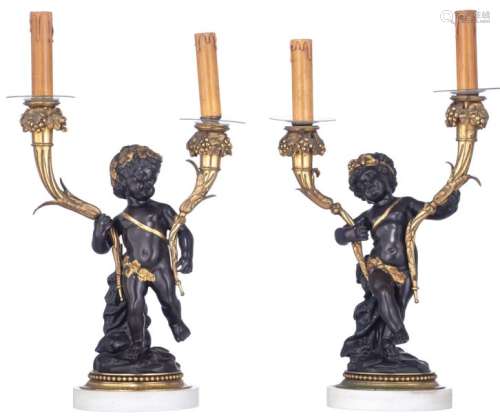 A pair of patinated and gilt bronze candlesticks s…