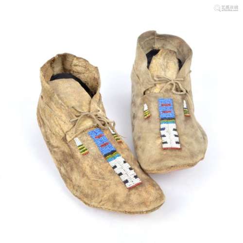 A pair of Arapaho moccasins. Plains. Hide with blu…