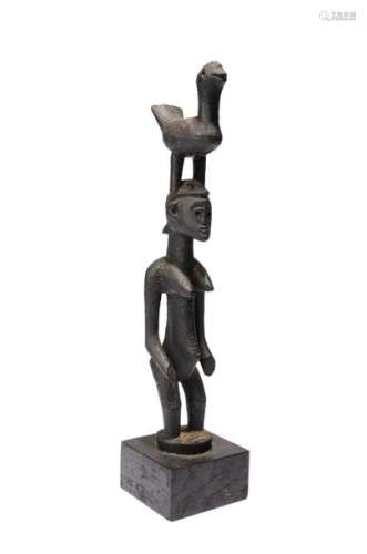A Senufo standing female figure. Ivory Coast. With…