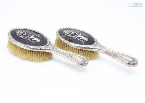 A pair of Edwardian silver and tortoiseshell hair brushes