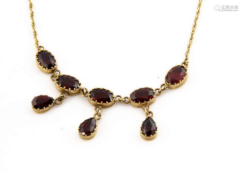 A 9ct gold garnet fringe necklace, the oval cut garnets supporting three tear cut pendants in claw